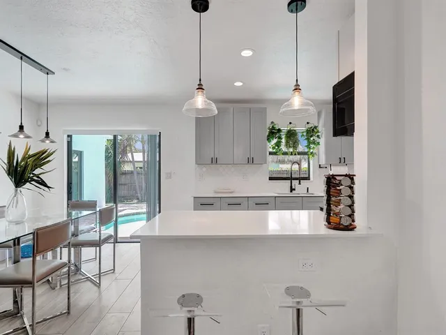 a kitchen with stainless steel appliances granite countertop a stove a sink and a wooden floor