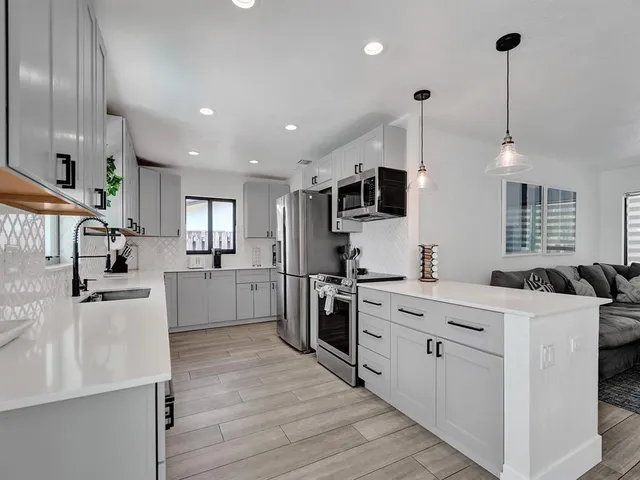 a kitchen with white cabinets and stainless steel appliances
