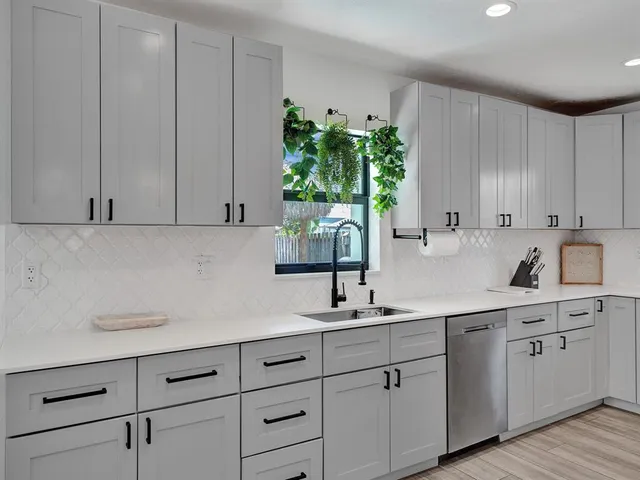 a kitchen with white cabinets and white appliances