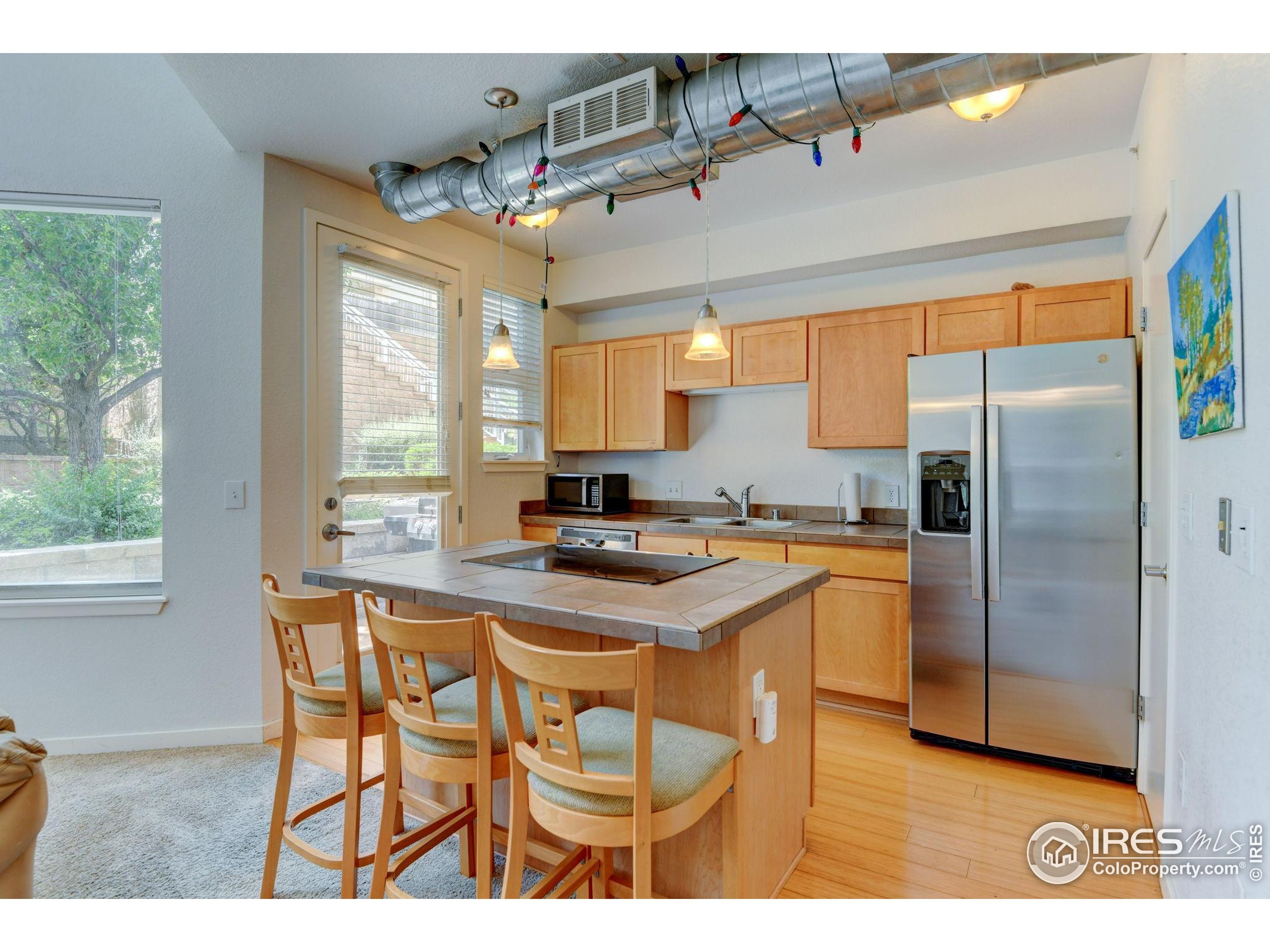 a kitchen with stainless steel appliances granite countertop a refrigerator a sink a stove and island