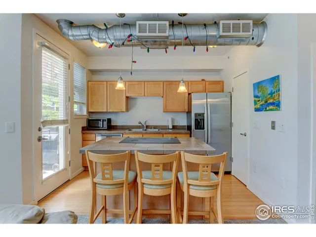 a kitchen with a table chairs refrigerator and cabinets