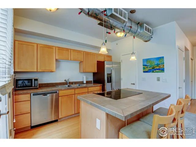 a kitchen with stainless steel appliances granite countertop a sink a refrigerator and a stove