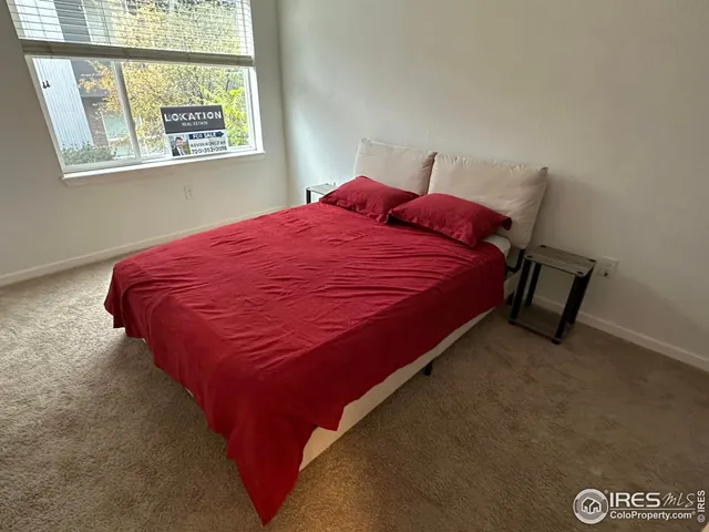 a bed sitting in a bedroom next to a window