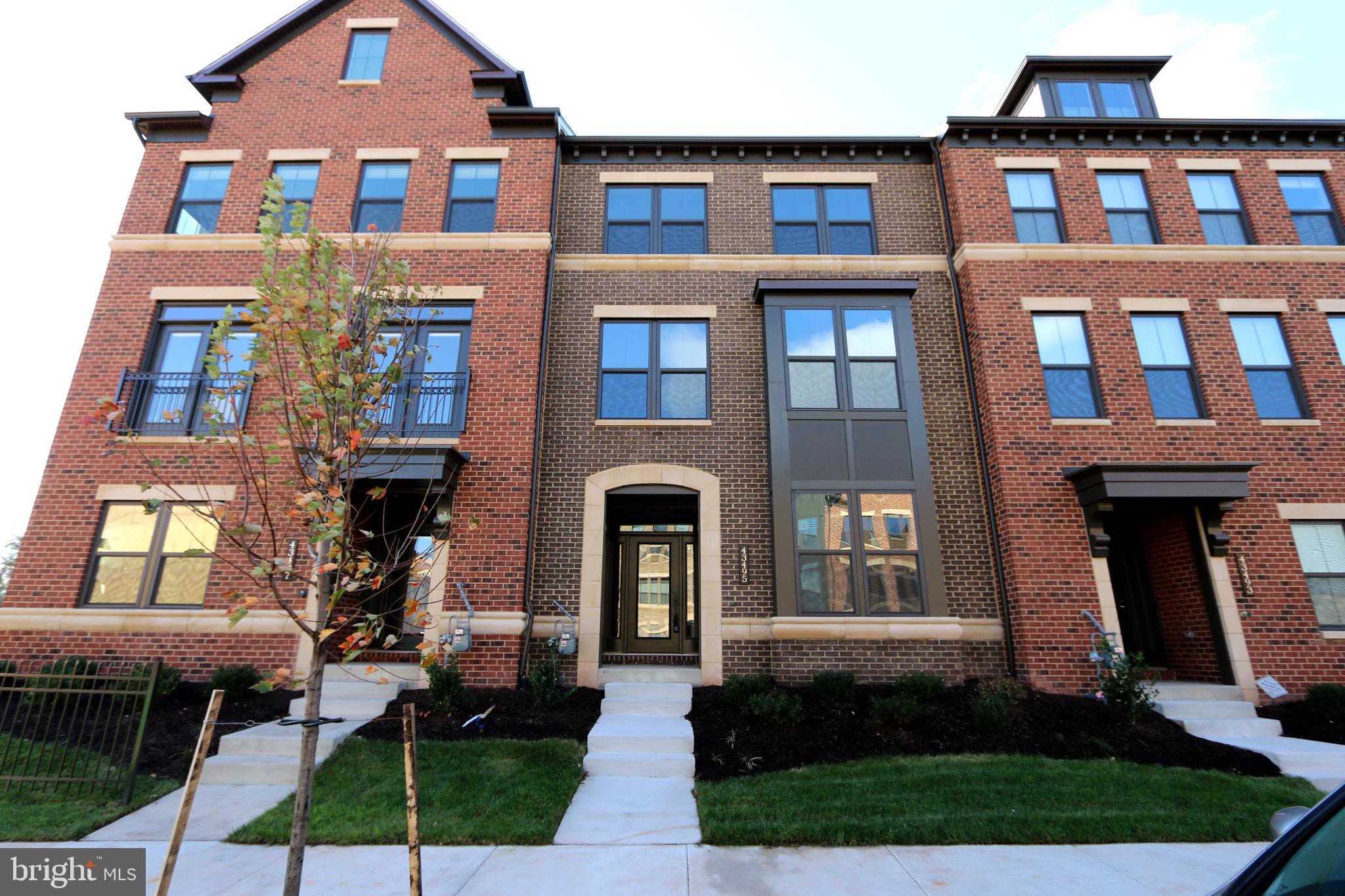 43495 Charitable Street Ashburn, VA 20148 - Photo 1 of 43 a front view of a residential apartment building with a yard