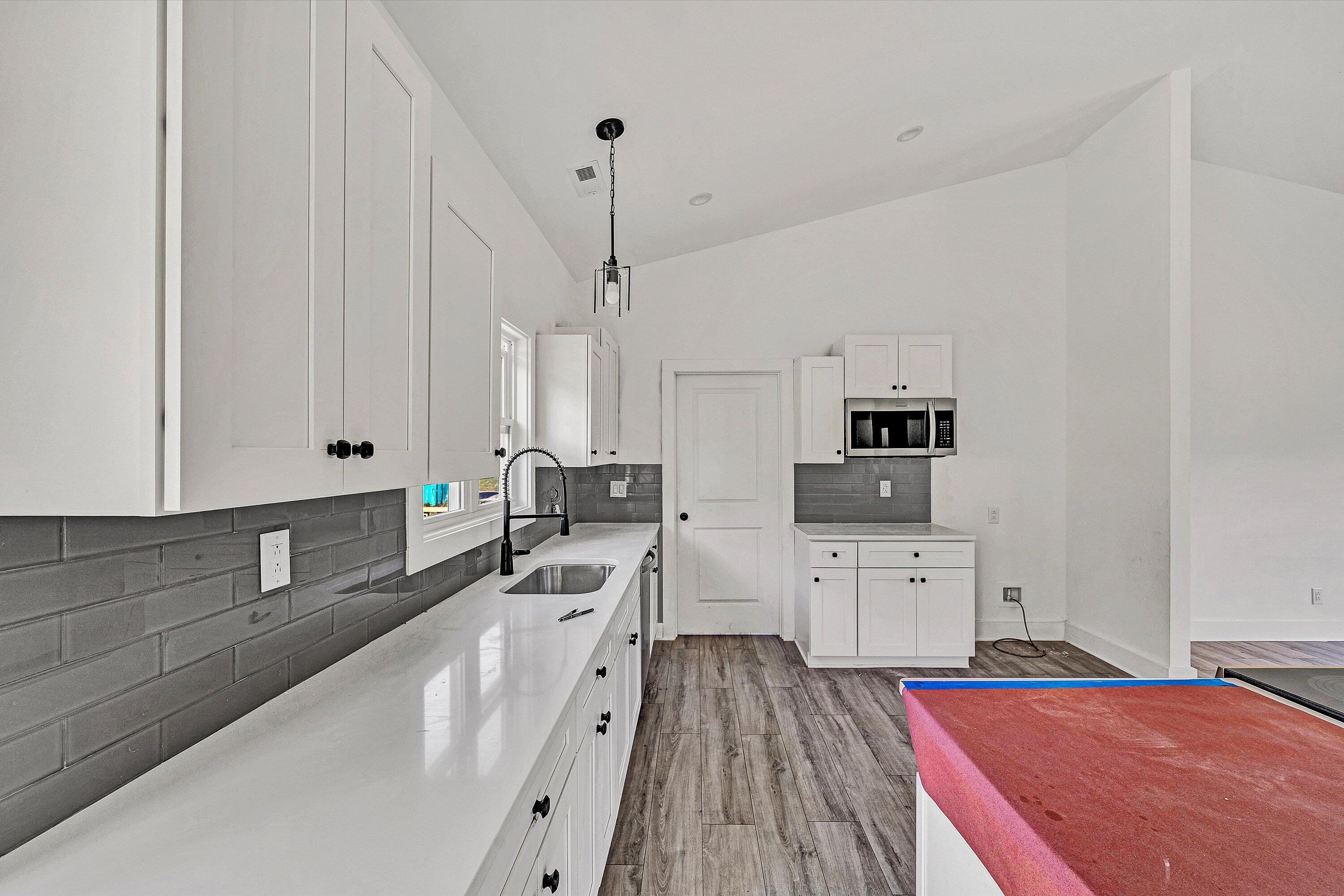 3086 Haymakertown Road Troutville, VA 24175 - Photo 7 of 16 a large white kitchen with sink stove and white cabinets with wooden floor