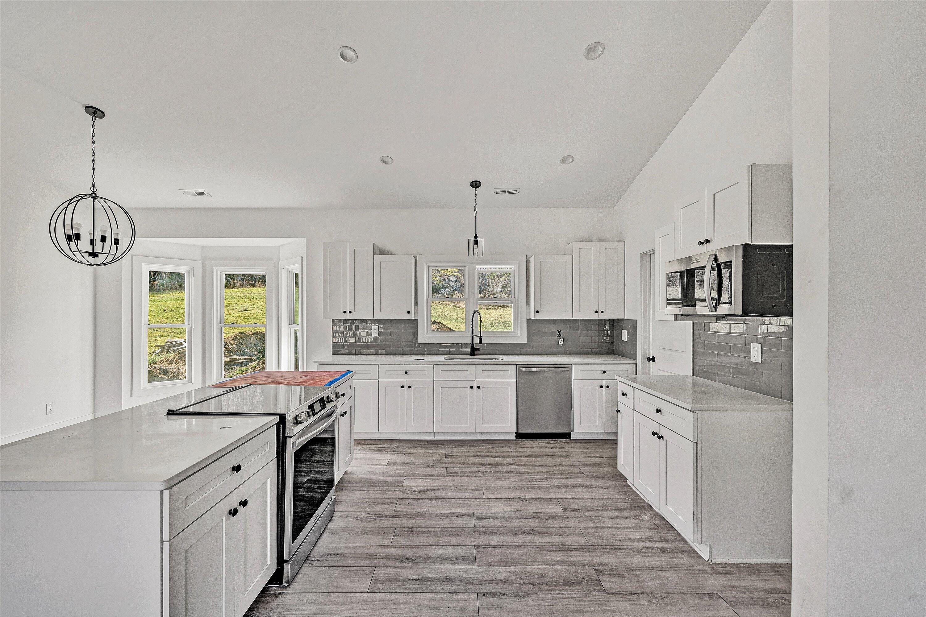 3086 Haymakertown Road Troutville, VA 24175 - Photo 8 of 16 a large kitchen with granite countertop a stove a sink dishwasher and a refrigerator with white cabinets
