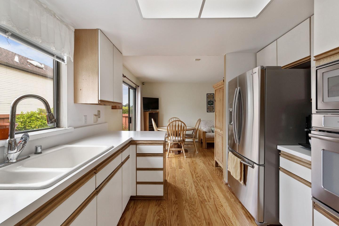360 Winwood Avenue Pacifica, CA 94044 - Photo 14 of 26 a kitchen with granite countertop a refrigerator a sink a stove and cabinets with wooden floor