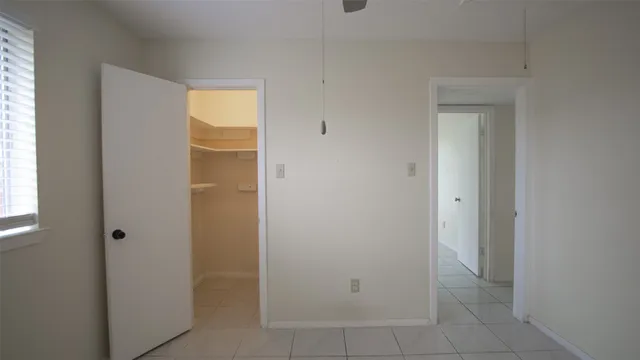 a view of an empty room with closet and a window