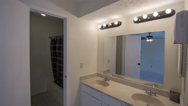 a bathroom with a sink vanity and shower