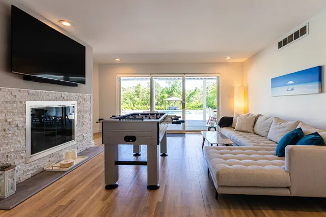 a living room with furniture a flat screen tv and a fireplace
