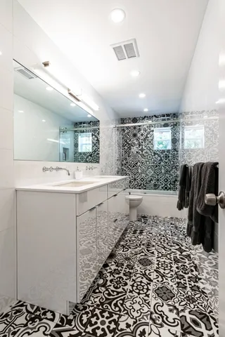a bathroom with a sink a toilet and mirror