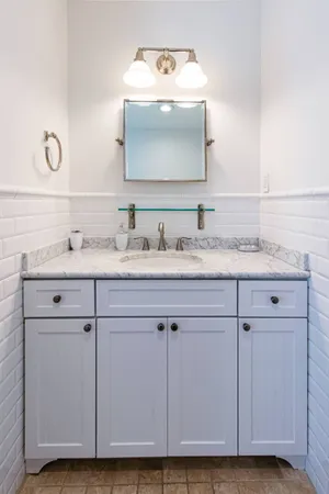 a bathroom with a sink vanity and a mirror