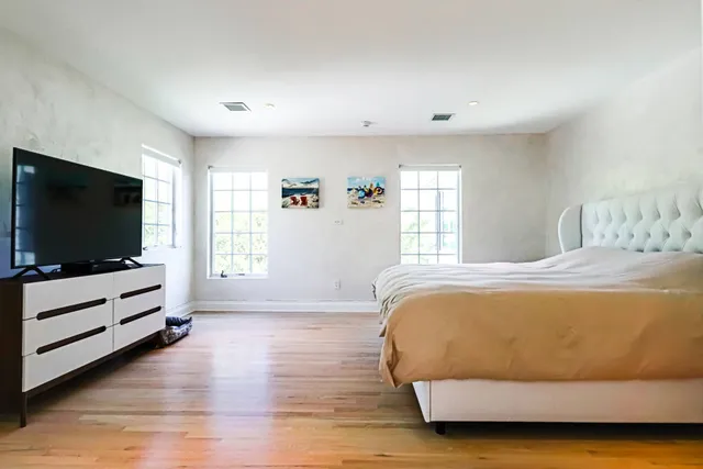 a bedroom with a bed and a flat screen tv