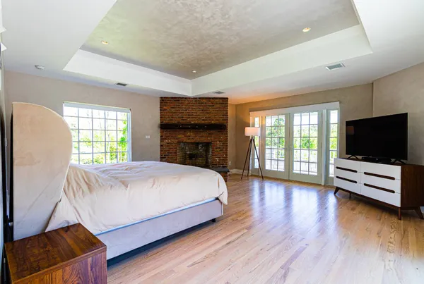 a spacious bedroom with a bed and a flat screen tv