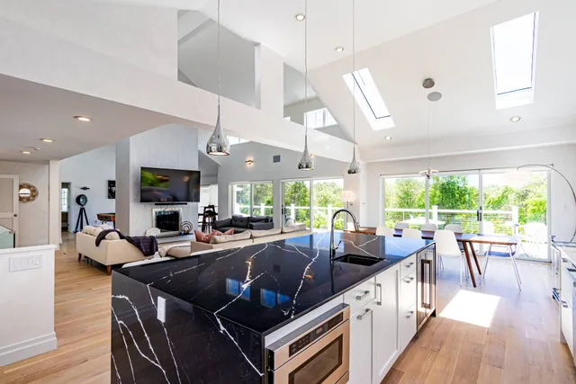 a living room with furniture large windows and wooden floor