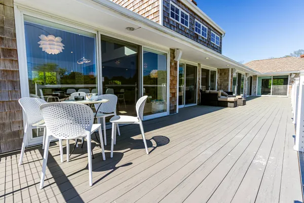 a view of a patio with table and chairs floor to ceiling window with wooden floor