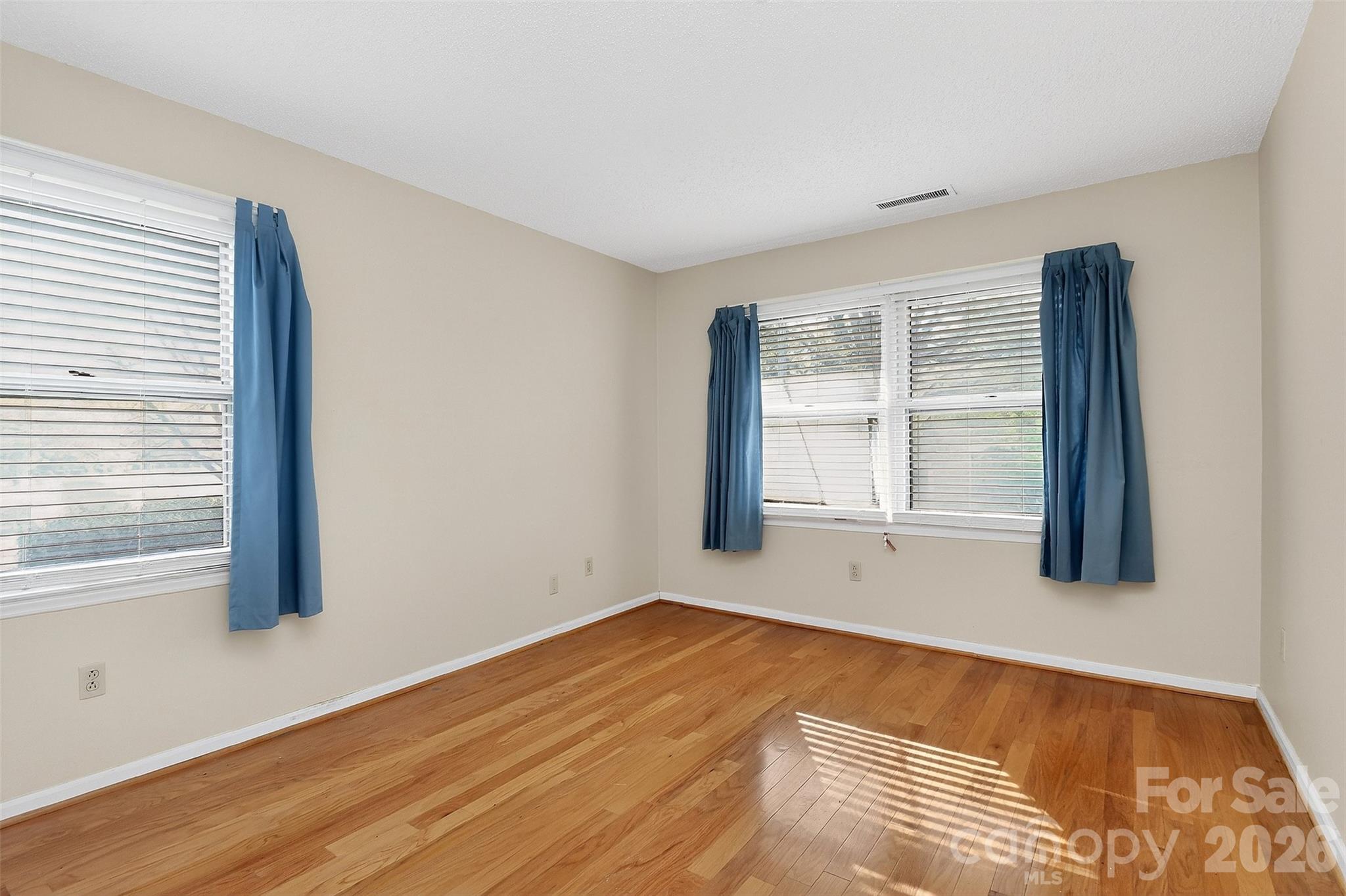 9516 Westmoreland Road Cornelius, NC 28031 - Photo 26 of 40 a view of an empty room with wooden floor and a window