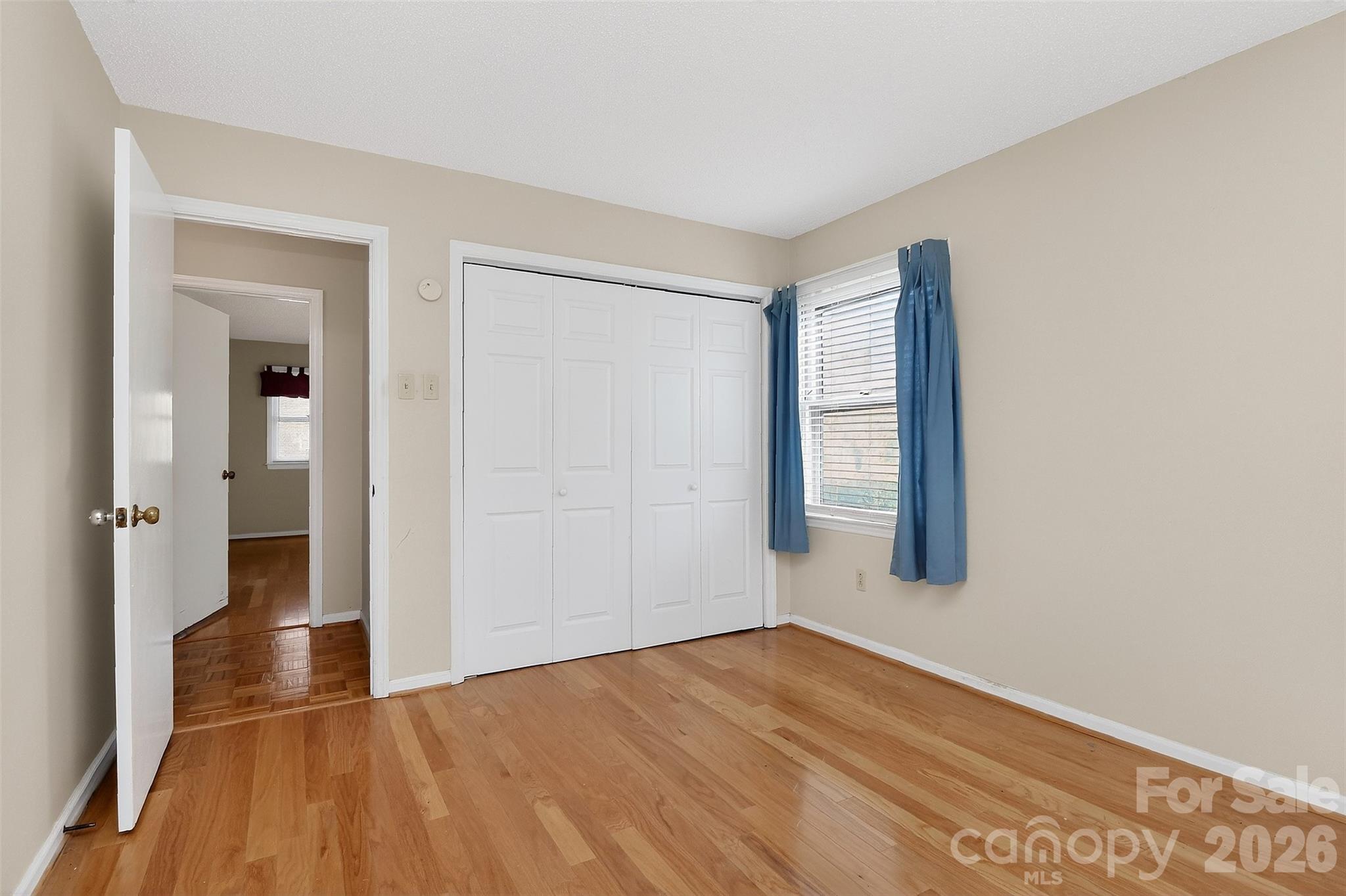 9516 Westmoreland Road Cornelius, NC 28031 - Photo 27 of 40 a view of an empty room with wooden floor and a window