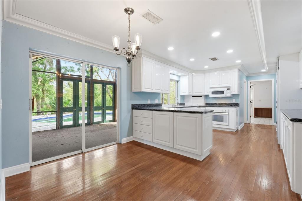 1840 Salem Court Dunedin, FL 34698 - Photo 16 of 64 a kitchen with stainless steel appliances granite countertop a refrigerator a sink dishwasher a stove and white countertops with wooden floor