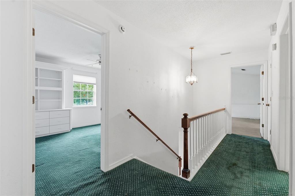 1840 Salem Court Dunedin, FL 34698 - Photo 26 of 64 a view of a hallway with white walls and stairs
