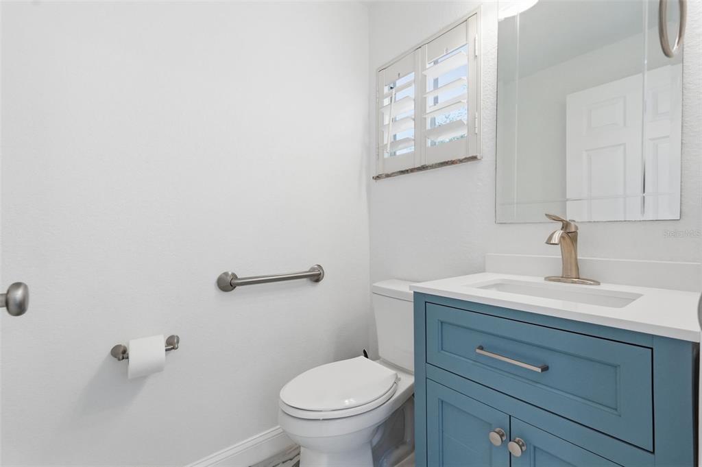 1840 Salem Court Dunedin, FL 34698 - Photo 51 of 64 a bathroom with a toilet a sink and mirror