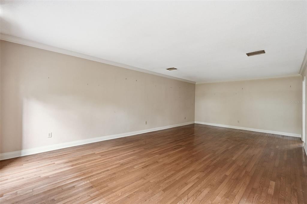 1840 Salem Court Dunedin, FL 34698 - Photo 7 of 64 a view of an empty room with wooden floor and a window