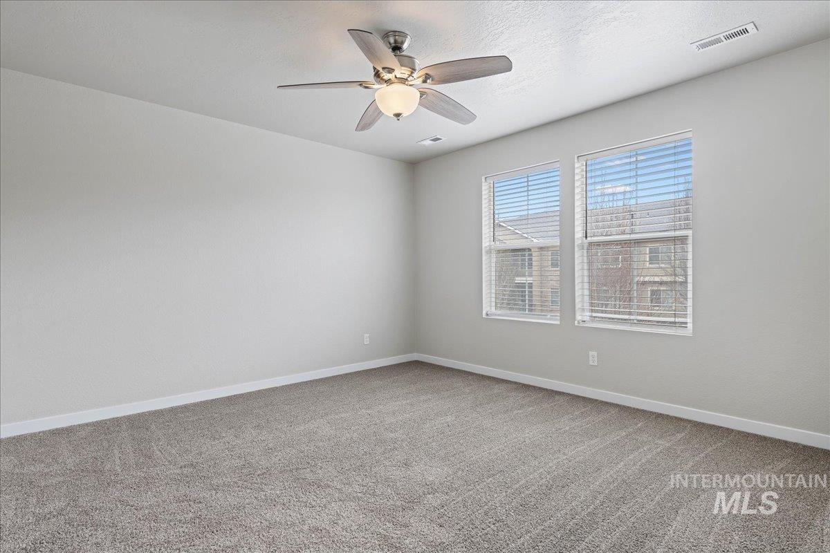 2500 East Blue Tick Street Meridian, ID 83642 - Photo 12 of 24 Unfurnished room with light colored carpet and a ceiling fan