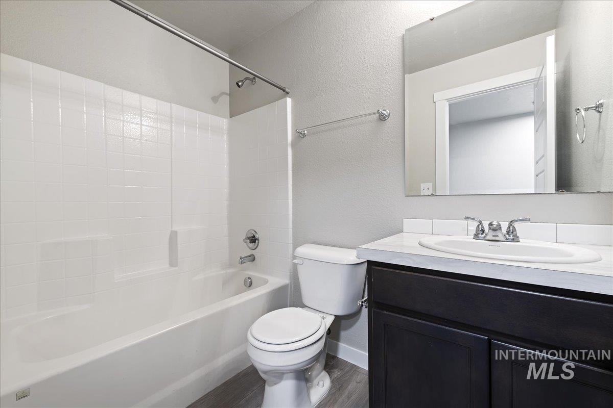 2500 East Blue Tick Street Meridian, ID 83642 - Photo 15 of 24 Full bathroom with a textured wall, shower / tub combination, vanity, and dark wood-style flooring