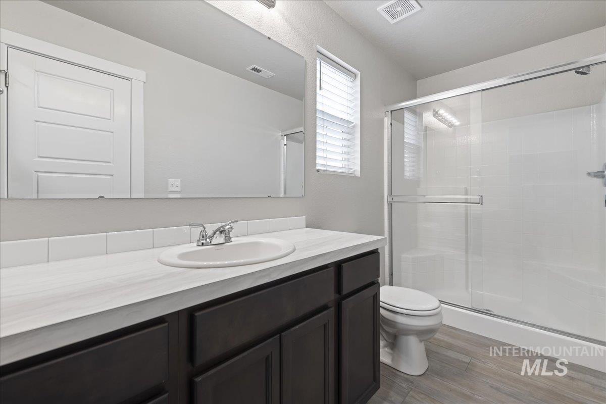 2500 East Blue Tick Street Meridian, ID 83642 - Photo 16 of 24 Full bath featuring vanity, a stall shower, and dark wood finished floors