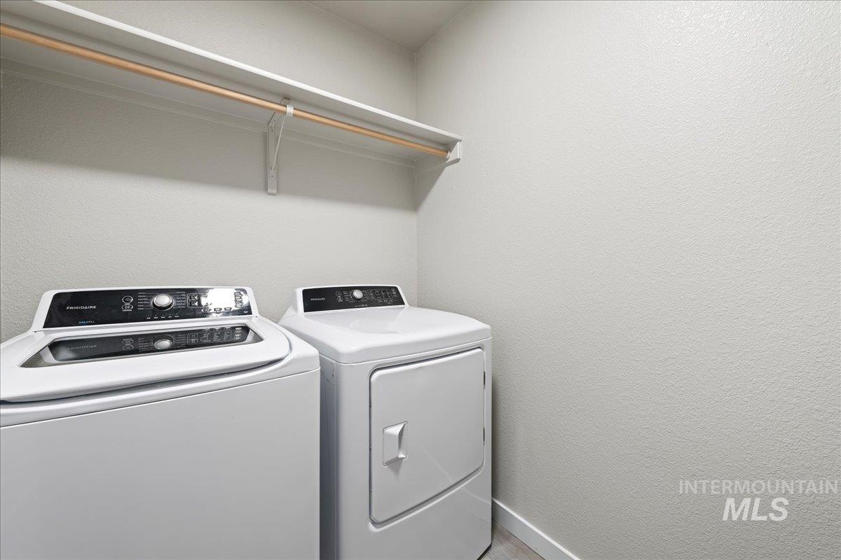 2500 East Blue Tick Street Meridian, ID 83642 - Photo 18 of 24 Laundry room featuring washer and clothes dryer and a textured wall