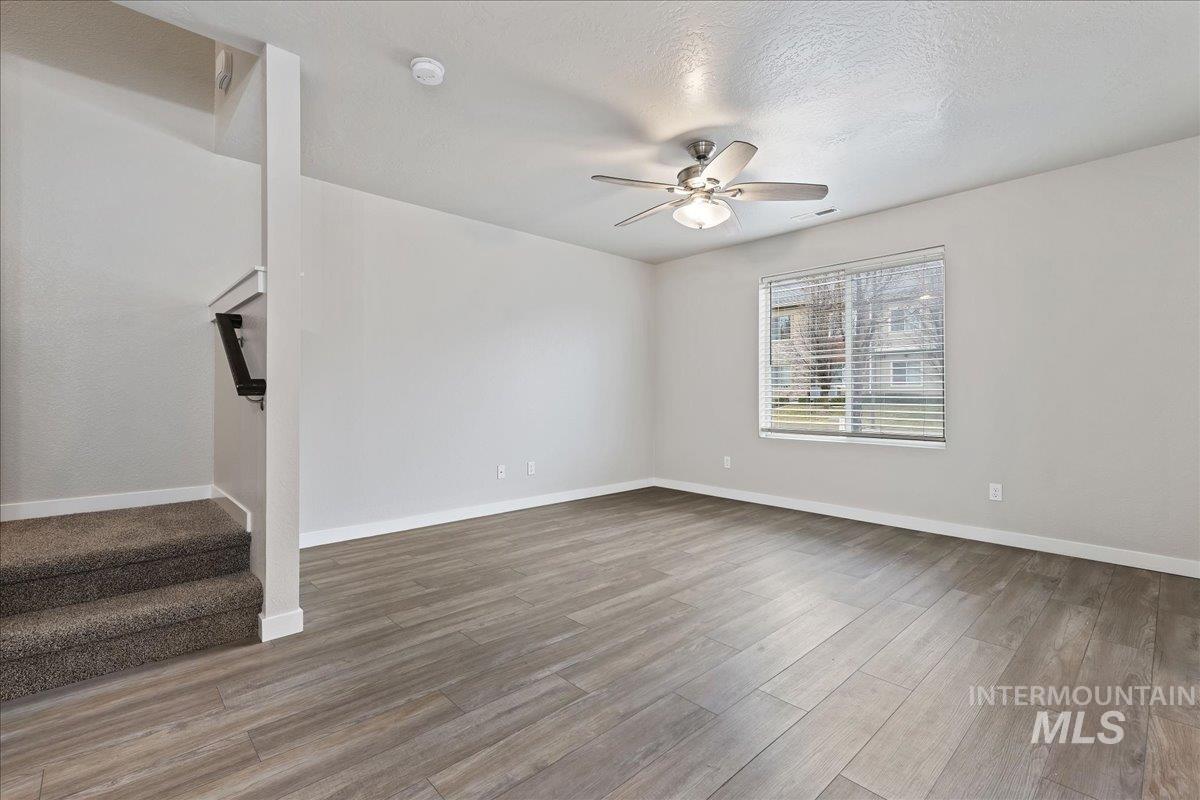 2500 East Blue Tick Street Meridian, ID 83642 - Photo 3 of 24 Unfurnished living room with light wood-type flooring, ceiling fan, and a textured ceiling