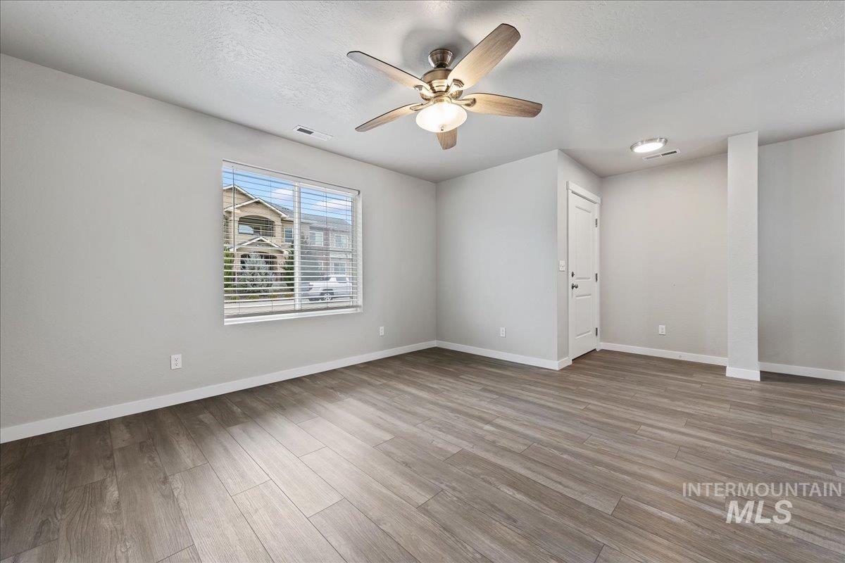 2500 East Blue Tick Street Meridian, ID 83642 - Photo 4 of 24 Spare room featuring a ceiling fan, light wood-style floors, and a textured ceiling