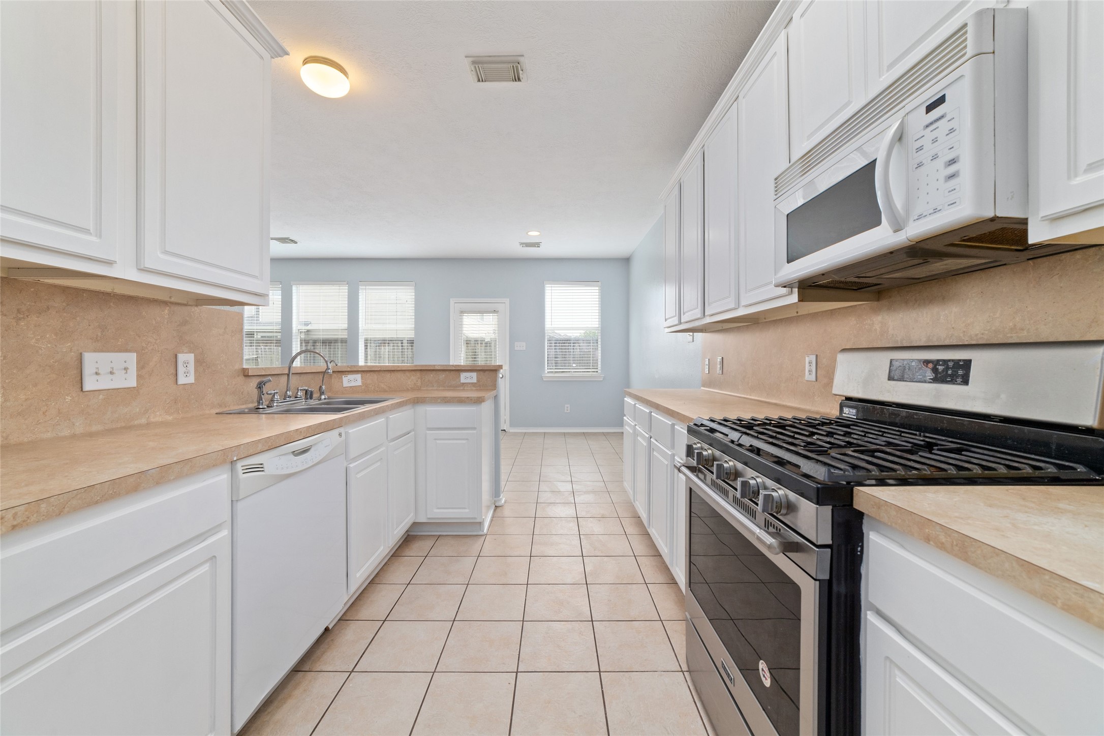 8734 Rainglen Lane Houston, TX 77044 - Photo 15 of 28 a large kitchen with stainless steel appliances granite countertop a stove a sink and a microwave