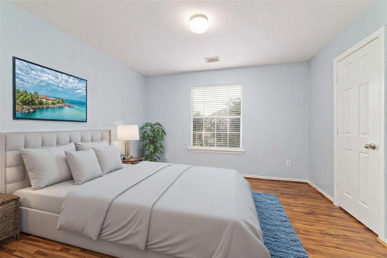 8734 Rainglen Lane Houston, TX 77044 - Photo 19 of 28 a bedroom with a bed and a painting on the wall