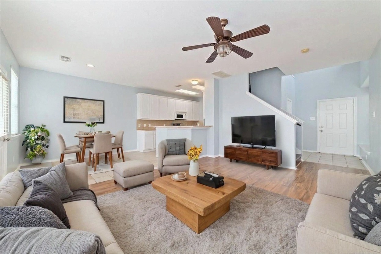 8734 Rainglen Lane Houston, TX 77044 - Photo 9 of 28 a living room with furniture and a flat screen tv with wooden floor