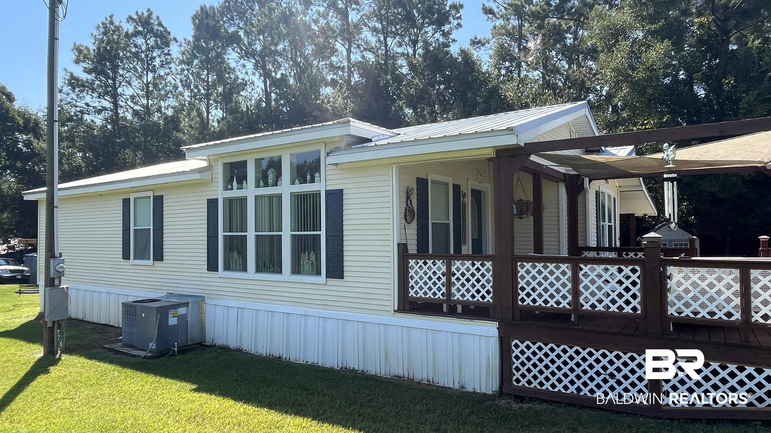 12932 Santa Piedro Street Lillian, AL 36549 - Photo 13 of 20 View of property exterior with a metal roof and a yard