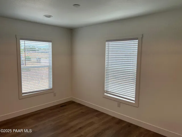 an empty room with wooden floor and a window