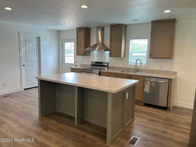 a kitchen with a sink cabinets and wooden floor