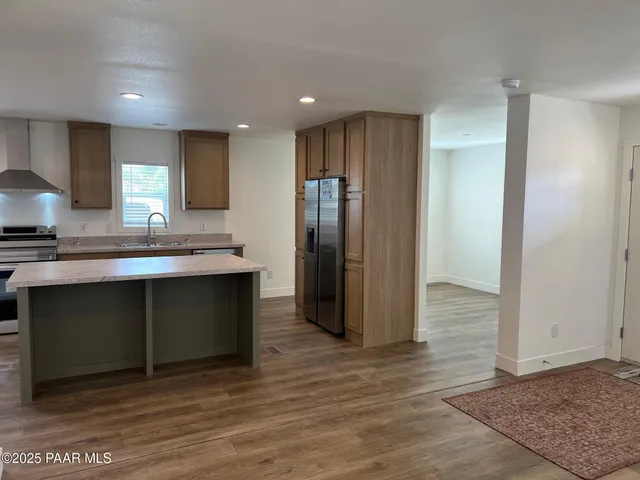 a kitchen with stainless steel appliances granite countertop a refrigerator and a sink