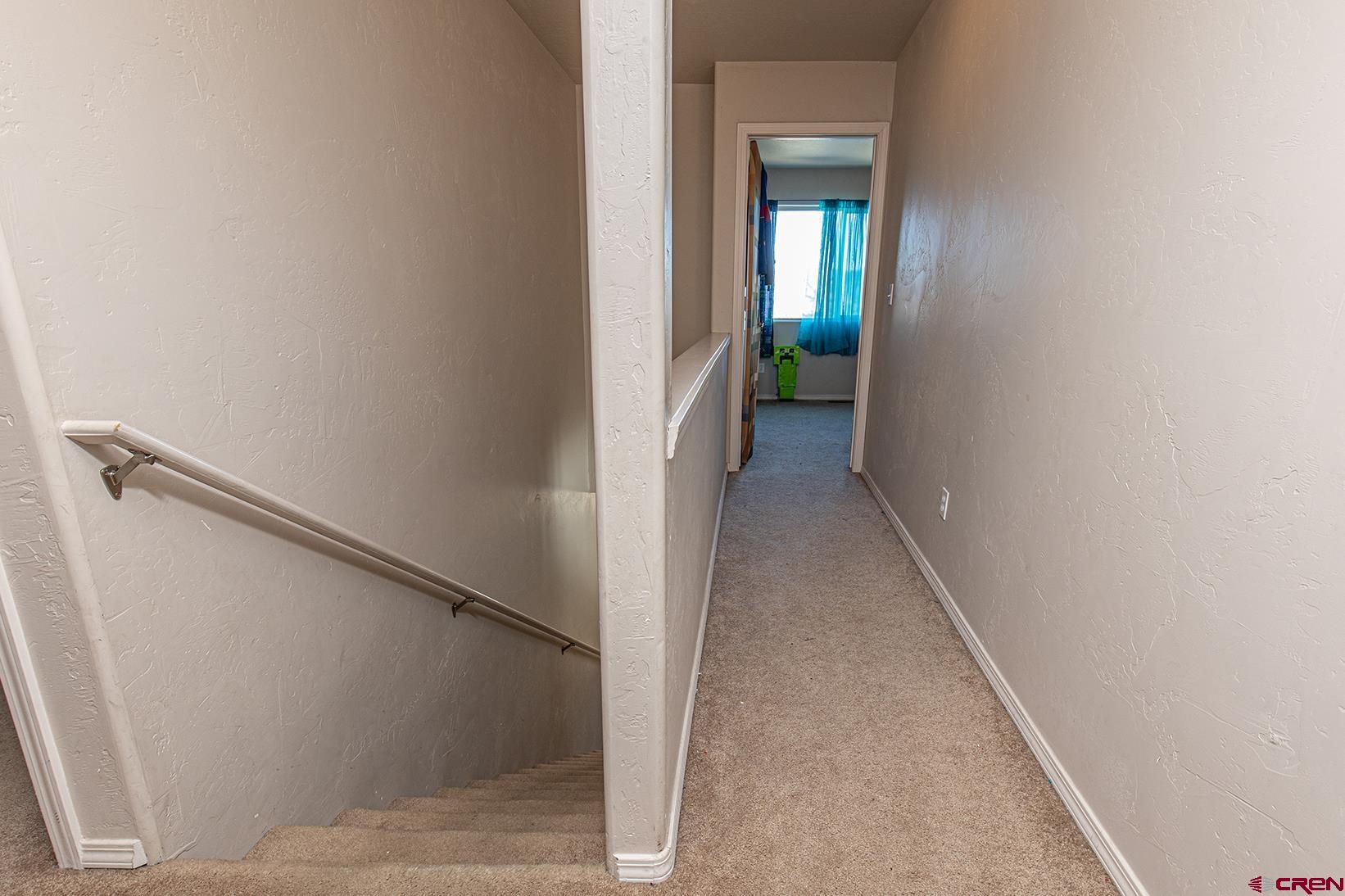 325 Star Crossing, Unit 2 Bayfield, CO 81122 - Photo 12 of 24 a view of a hallway with wooden floor and staircase