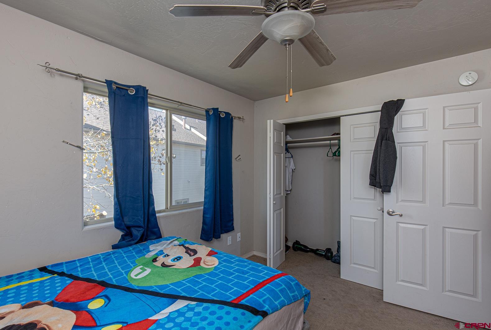 325 Star Crossing, Unit 2 Bayfield, CO 81122 - Photo 18 of 24 a bedroom with a bed and a chandelier