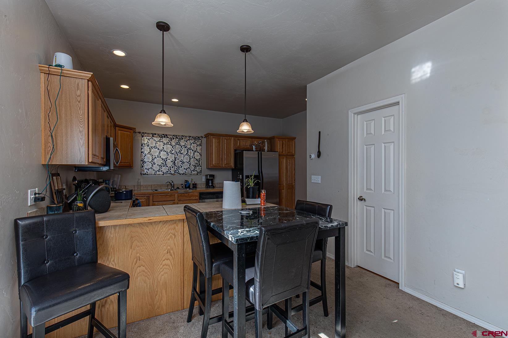 325 Star Crossing, Unit 2 Bayfield, CO 81122 - Photo 7 of 24 a kitchen with a dining table chairs and cabinets