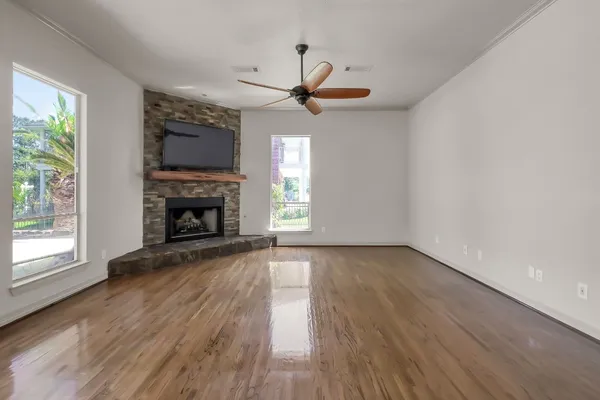 a view of an empty room with a window and wooden floor