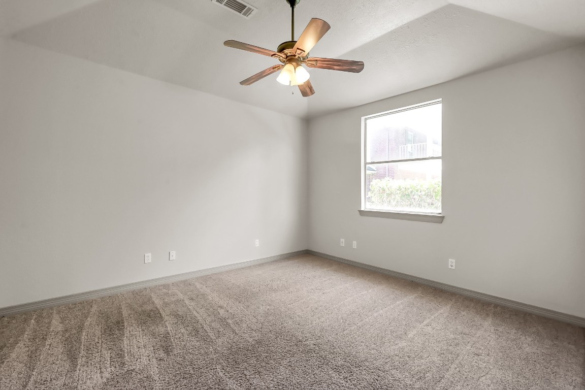 12758 Aries Loop Willis, TX 77318 - Photo 21 of 48 an empty room with windows and chandelier fan