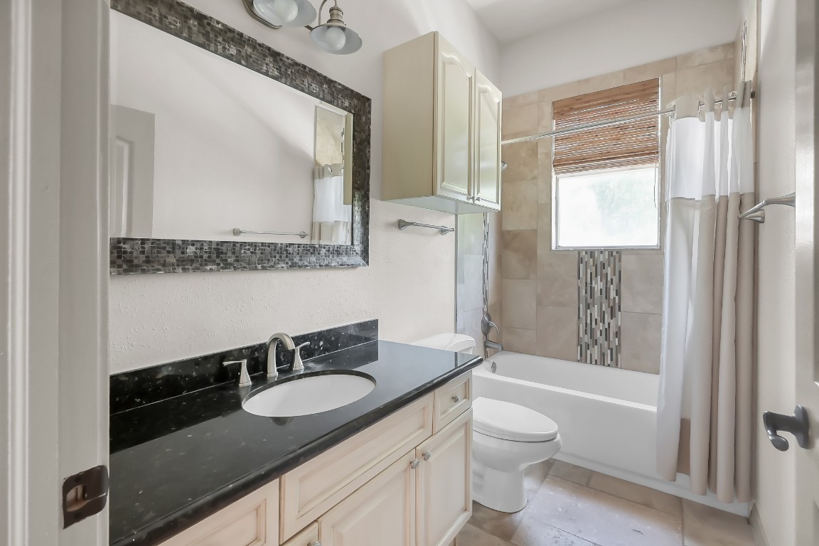 12758 Aries Loop Willis, TX 77318 - Photo 22 of 48 a bathroom with a granite countertop sink toilet a mirror and shower