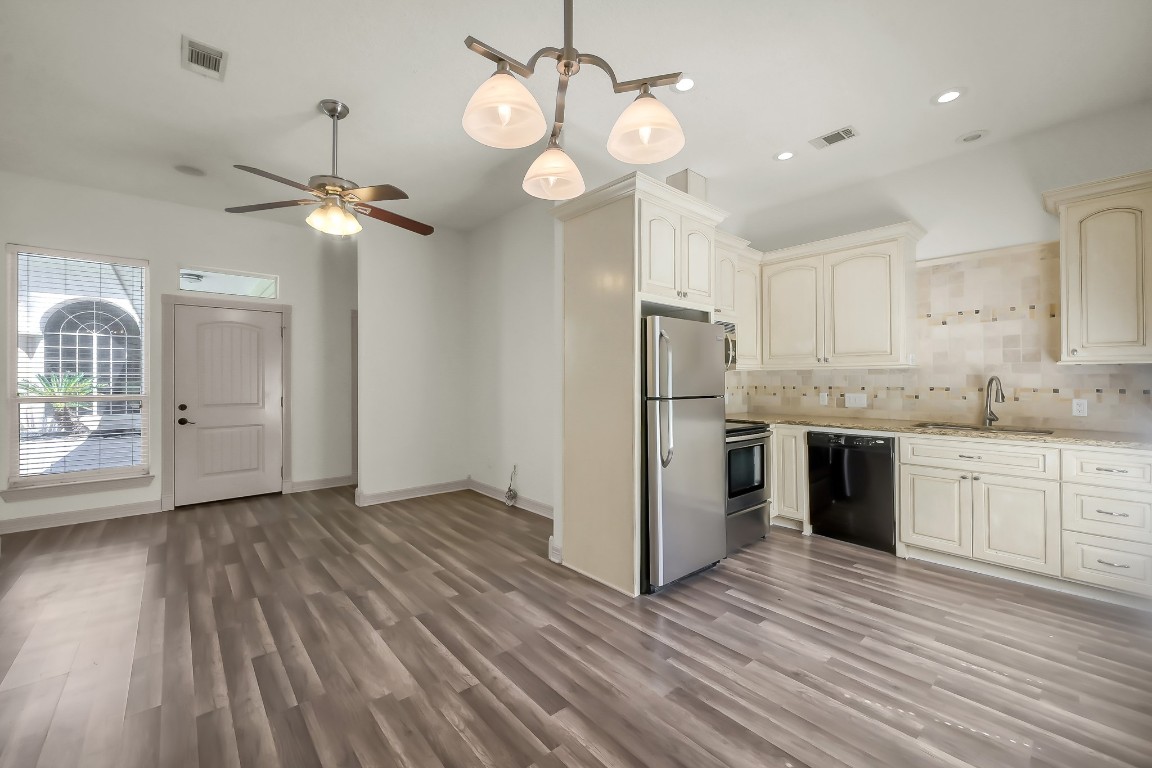 12758 Aries Loop Willis, TX 77318 - Photo 45 of 48 a view of a kitchen with a refrigerator wooden floor and a window