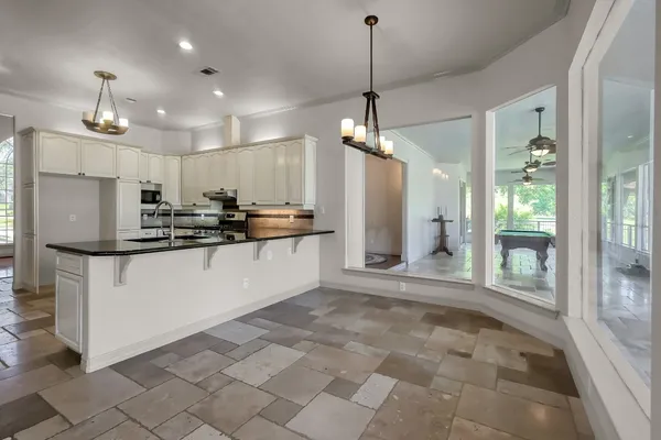 a bathroom with a granite countertop sink toilet a mirror and shower