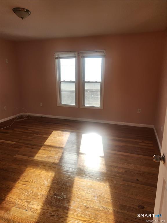 141 Hicks Street Bridgeport, CT 06608 - Photo 7 of 16 a view of empty room with wooden floor and fan