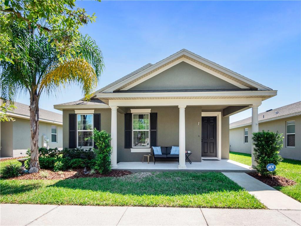 a view of a house with a yard plants and palm trees