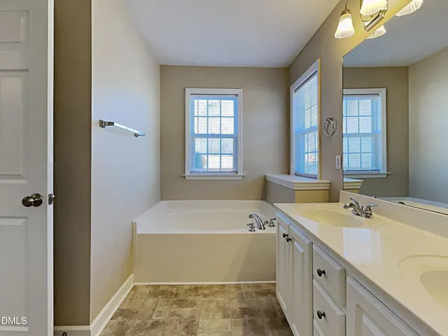 a bathroom with a tub sink and mirror